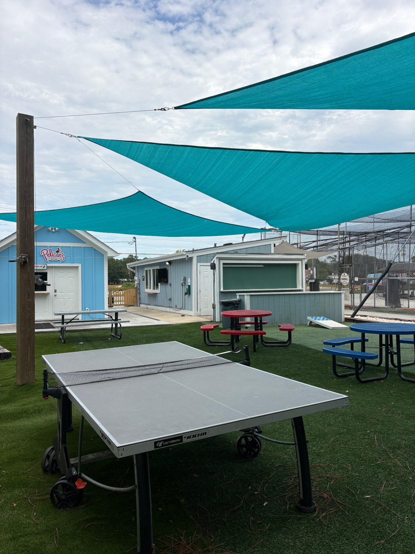 Ping pong and cornhole games on the turf beer garden at Bats and Brews